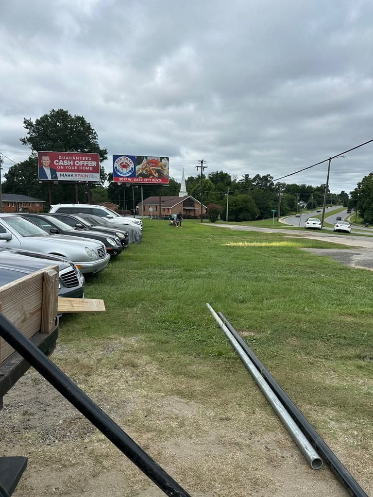 Black chain-link perimeter fence around a parking lot