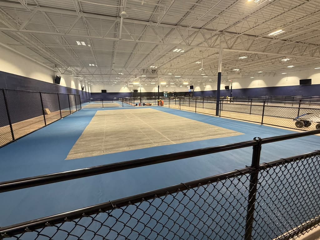 Black chain-link fencing around indoor sports courts